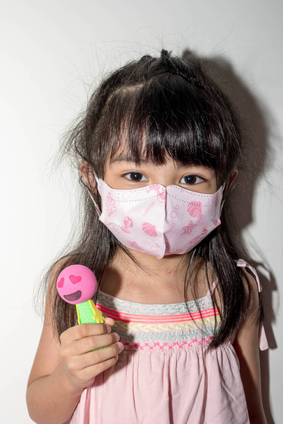 Asiatique enfant de 5 ans portant le masque chirurgical pour protéger la ge
 - Photo, image