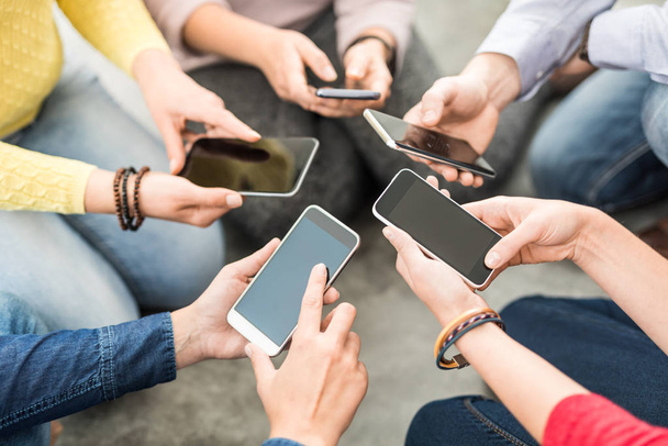 Grupa młodych Awangarda trzymając telefon w ręce. Przyjaciele zabawy wraz z smartfonów. - Zdjęcie, obraz