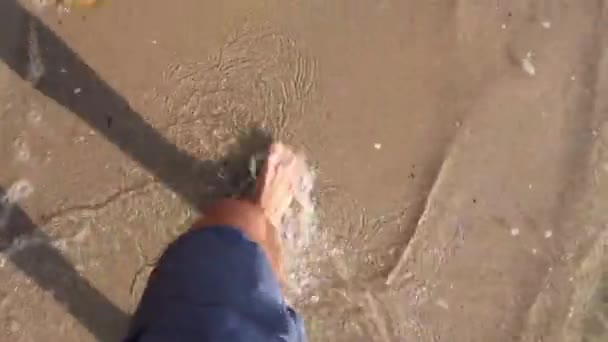 Az ember lába belép a tiszta sekély vízbe.Az ember lába, amíg mezítláb át nem sétál a sekély tengervízen. H.264 videó codec - Felvétel, videó
