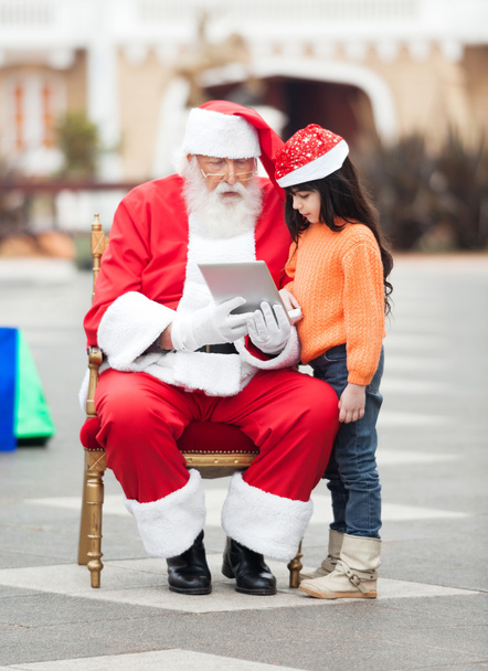 Santa Claus And Girl Using Digital Tablet - Foto, afbeelding