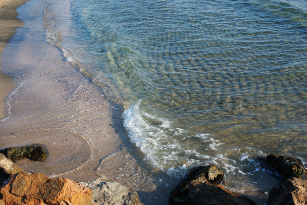 Sonniger Tag mit meerklarem Wasser mit Wellen am Strand - Foto, Bild