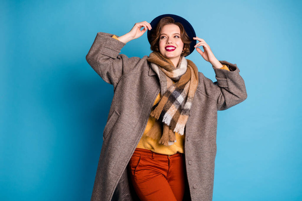 Photo of traveler lady toothy smiling good mood sunny day weather wear stylish casual long grey coat yellow pullover orange pants hat isolated blue color background - Foto, immagini