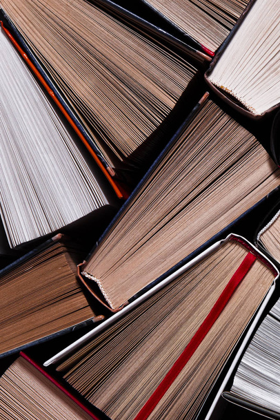 Sok színes vastag nyitott könyvek állni egy sötét háttér - Fotó, kép