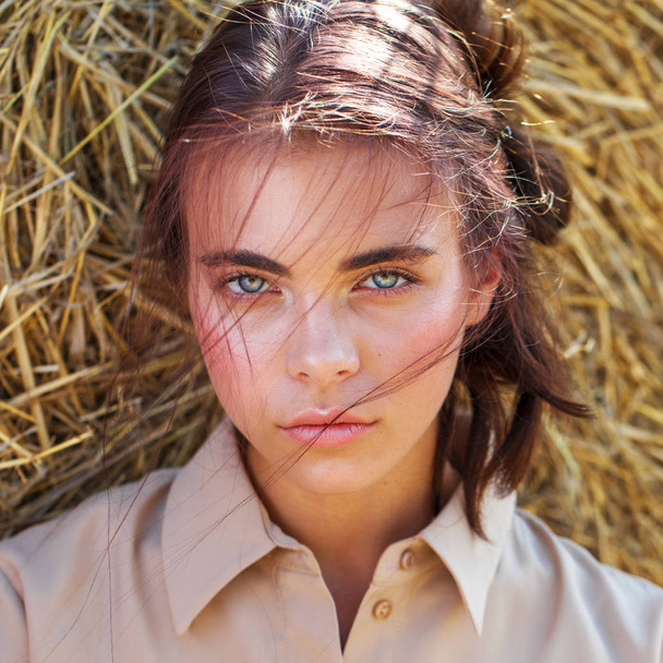 Beautiful girl in a beige dress posing on a background of haysta - Zdjęcie, obraz