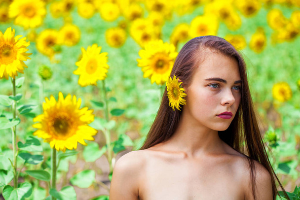 Photo of pretty brunette woman in sunflowers field - Фото, зображення
