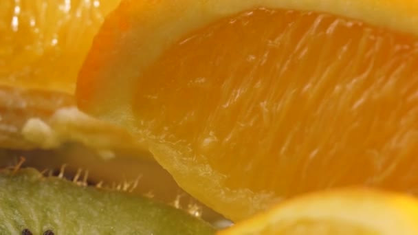 Juicy slices of orange and kiwi lie on the table macro photography - Кадри, відео