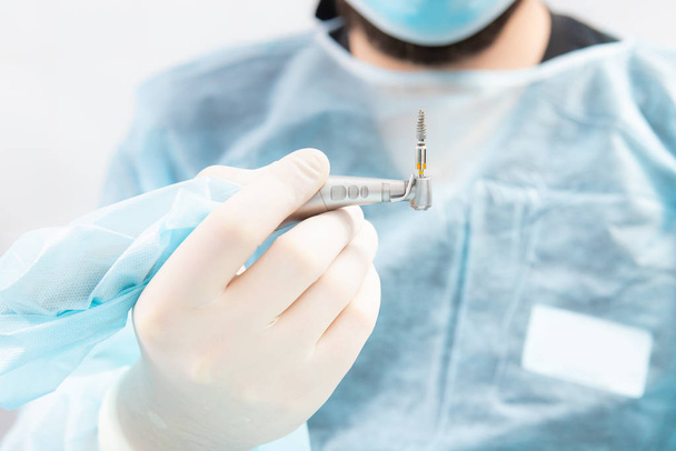 A modern implantation tool is fixed on a dental drill. Close up, macro photo. - Foto, Bild
