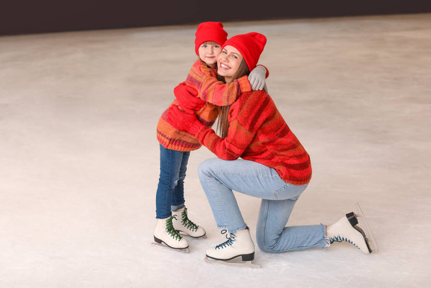 Jonge moeder met dochtertje op schaatsbaan - Foto, afbeelding