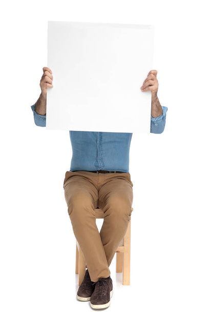 Old casual man covering his face with a blank billboard - Foto, imagen