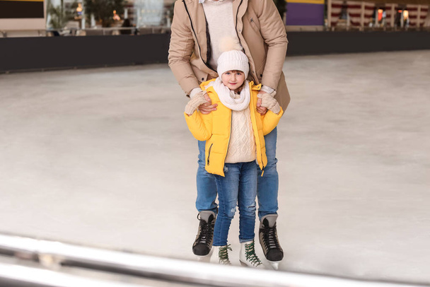 Young father with little daughter on skating rink - Photo, Image