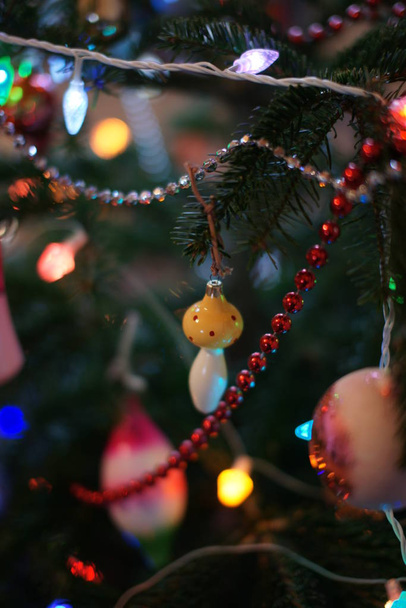green fir tree with colored toys and garlands in room background - Fotografie, Obrázek