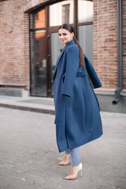 Gyönyörű, elegáns hölgy kék kabátban és magassarkúban.. - Fotó, kép