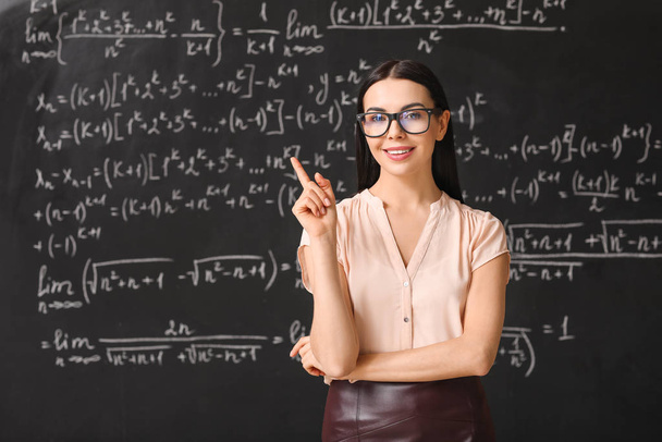 Female teacher near blackboard in classroom - Photo, Image