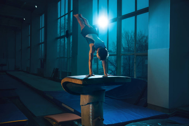 Pequeño entrenamiento de gimnasta masculino en gimnasio, flexible y activo
 - Foto, Imagen