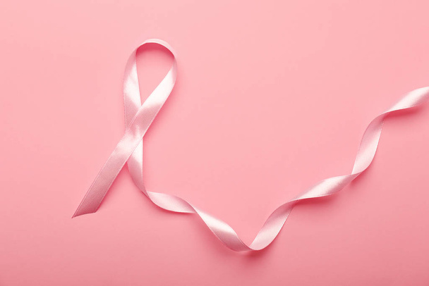 Pink ribbon on color background. Breast cancer awareness concept - Photo, image