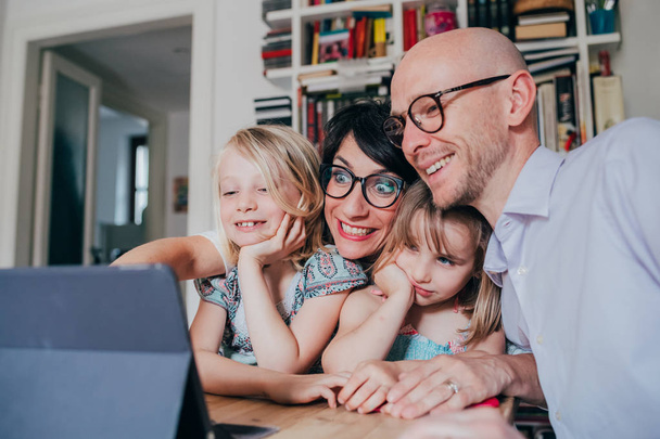 família com três crianças em casa usando tablet
  - Foto, Imagem