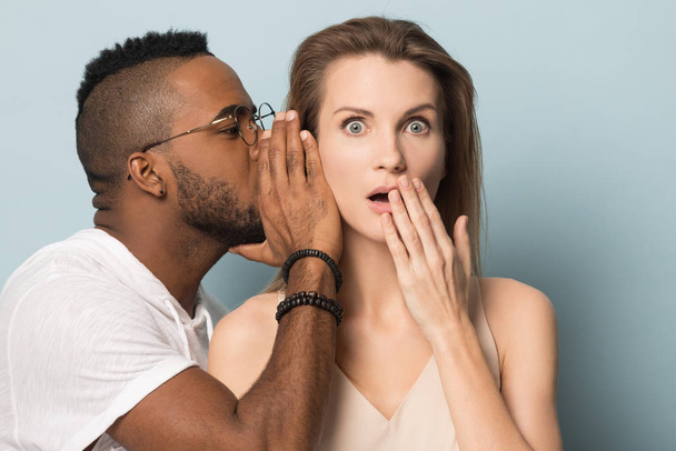 African American man tell secret to shocked caucasian female - Foto, imagen