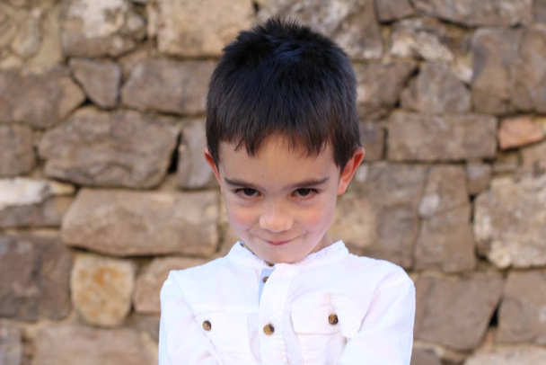 Detailní portrét roztomilého chlapečka stojící na cihlové zdi pozadí  - Fotografie, Obrázek