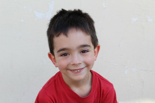 Beyaz tişörtlü, kırmızı tişörtlü bir çocuğun yakın plan portresi.  - Fotoğraf, Görsel