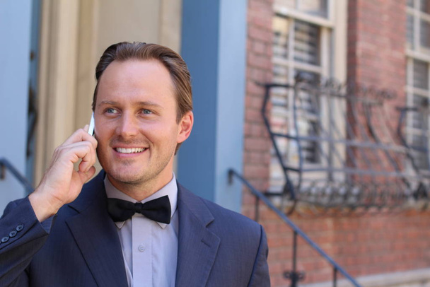 Portrait of handsome businessman talking on phone outdoors in London - Photo, Image