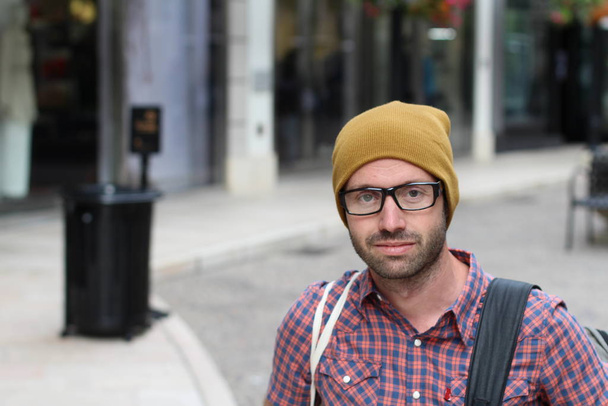Outdoor portrait of hip man wearing eyeglasses and hat - 写真・画像