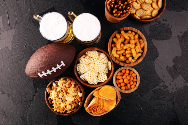 Chips, salzige Snacks, Fußball und Bier auf einem Tisch. ideal für Verbeugung - Foto, Bild
