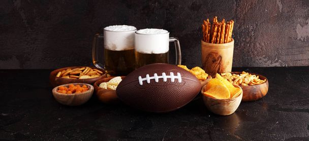 Chips, salty snacks, football and Beer on a table. Great for Bow - Фото, изображение