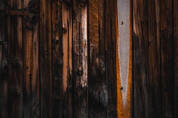 A closeup shot of a wood fence with charred lower part - Fotografie, Obrázek