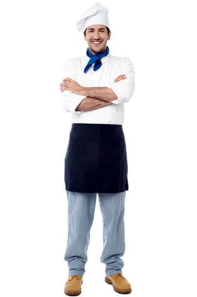 Впевнений молодий шеф-кухар в білій формі і капелюсі
 - Фото, зображення