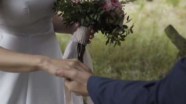 Gelukkige pasgetrouwden slaan de handen ineen op een trouwdag. - Video