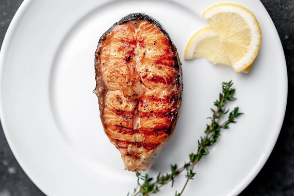 vue de dessus du steak de saumon grillé dans une assiette blanche avec des épices sur un fond de pierre
 - Photo, image