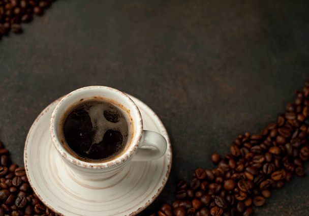 Vista angular de la taza de sabroso café y frijoles sobre un fondo de piedra
.  - Foto, Imagen