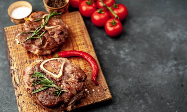 gegrilltes Steak mit Tomaten und Gewürzen auf Steingrund  - Foto, Bild