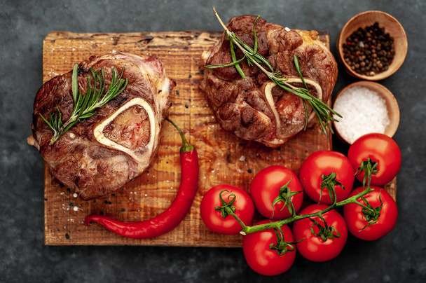 grilled steak, with tomatoes and spices on a stone background  - 写真・画像
