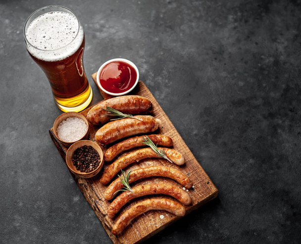 Various grilled sausages with spices on a stone table - Photo, Image