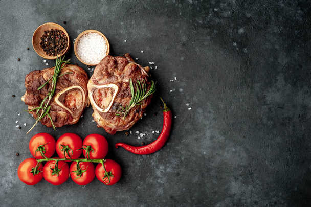 Steaks vom Grill, mit Tomaten und Gewürzen auf Steinhintergrund  - Foto, Bild