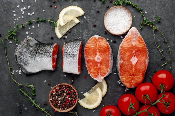 fresh raw salmon steaks and salmon tail on a stone background - Фото, изображение