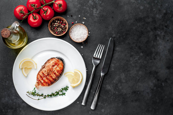 vista dall'alto di bistecca di salmone alla griglia in un piatto bianco con spezie su uno sfondo di pietra
 - Foto, immagini