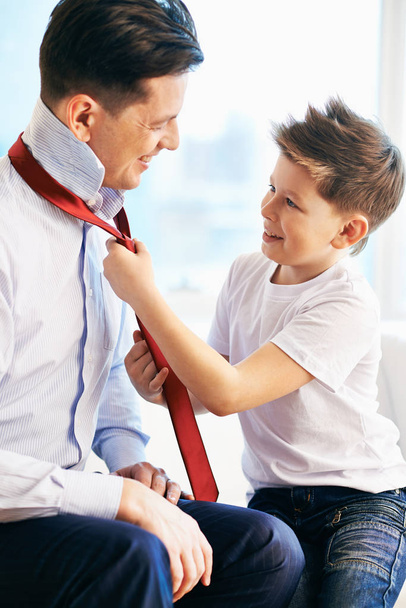 Photo of happy boy tying necktie of his father - Zdjęcie, obraz