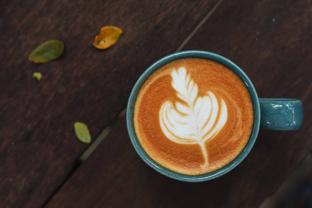 warme latte koffie drinken gezet op houten tafel in de ochtend dag - Foto, afbeelding