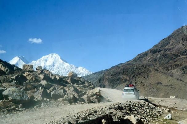 Пешеходный автомобиль, движущийся по извилистой горной дороге, ведущий транспортное средство к базовому лагерю Эверест. Захватывающие горные Гималаи ледники долины пейзажей в фоновом режиме. Непал Индия Май 2019
 - Фото, изображение