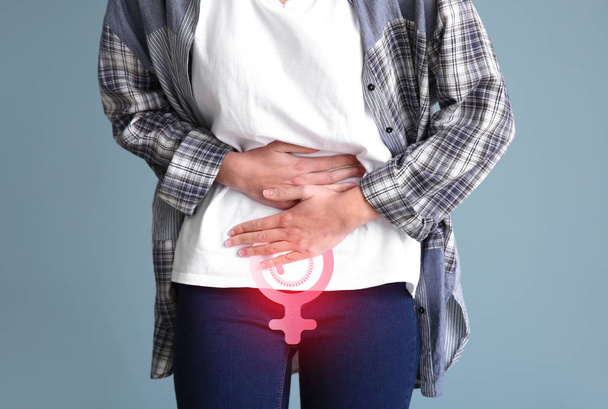 Fiatal nő szenved menstruációs görcsök színes háttér - Fotó, kép