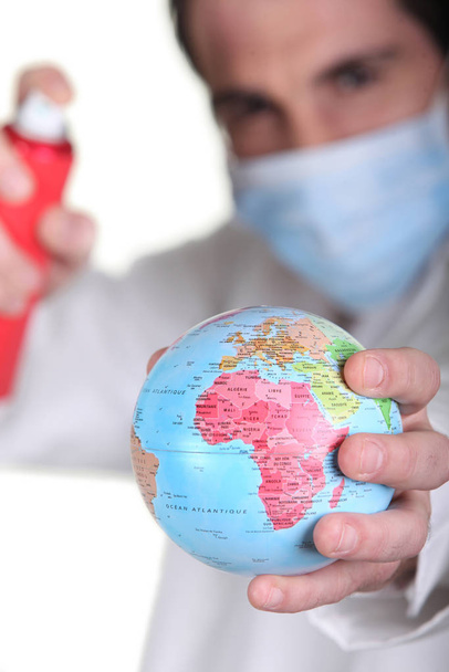 Doctor holding miniature globe - Zdjęcie, obraz