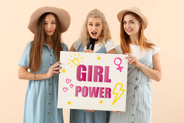 Όμορφες νεαρές γυναίκες κρατώντας αφίσα με κείμενο Κορίτσι Δύναμη στο φόντο χρώμα - Φωτογραφία, εικόνα