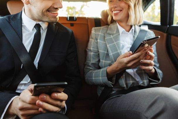 Image of young businesslike man and woman using smartphones in c - Foto, Imagen