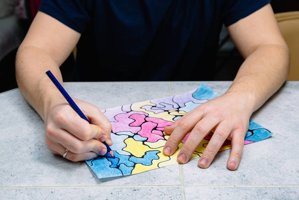 muž kreslí abstraktní imaginární obrázek tužkou a zdobí ho různými barvami, psychologickým testem - Fotografie, Obrázek