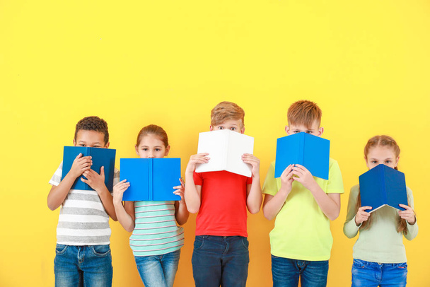 Милі маленькі діти з книгами на кольоровому фоні
 - Фото, зображення