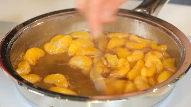 Hámozott mandarin narancsfilé cukorral és serpenyőben - Felvétel, videó