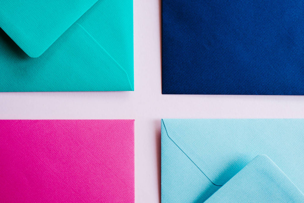 Colored paper envelopes on a light background. New mail, write message. Send and receive letter. Postal delivery service. Blank envelope, empty space. People communication, paperwork. Envelope closeup - Fotografie, Obrázek