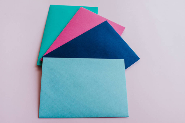 Colored paper envelopes on a light background. New mail, write message. Send and receive letter. Postal delivery service. Blank envelope, empty space. People communication, paperwork. Envelope closeup - Foto, immagini